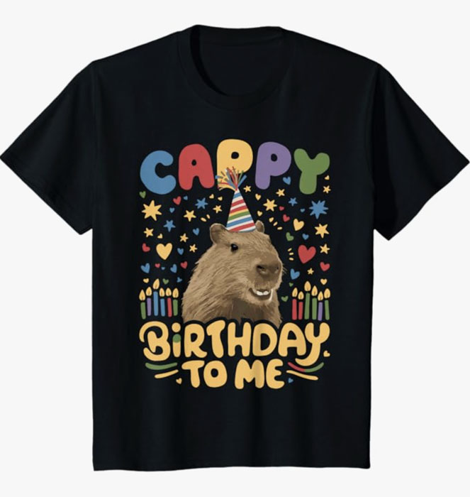 Black birthday t-shirt with capybara wearing party hat, colorful stars, hearts, and candles, text reading “Cappy Birthday To Me.”